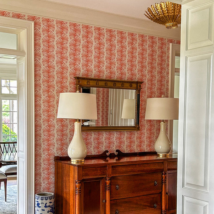 Emma Coral wallpaper with vibrant coral leaf pattern in a bright room, made-to-order with short lead times, manufactured in the USA