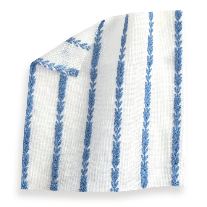 sheer white fabric swatch with embroidered cobalt blue stripes on it