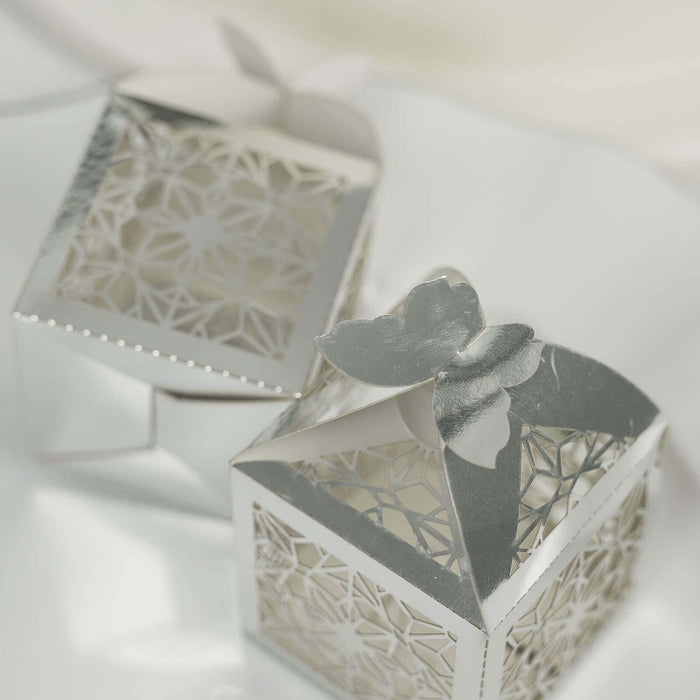 Silver decorative gift boxes with intricate cut-out designs.