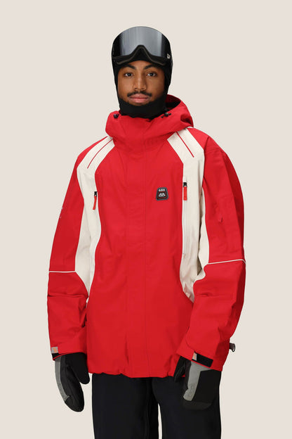 A person wearing the 686 Men's 2002 X3 3L Shell Jacket, black gloves, a black helmet, and ski goggles stands against a plain light background.
