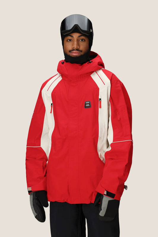 A person wearing the 686 Men's 2002 X3 3L Shell Jacket, black gloves, a black helmet, and ski goggles stands against a plain light background.
