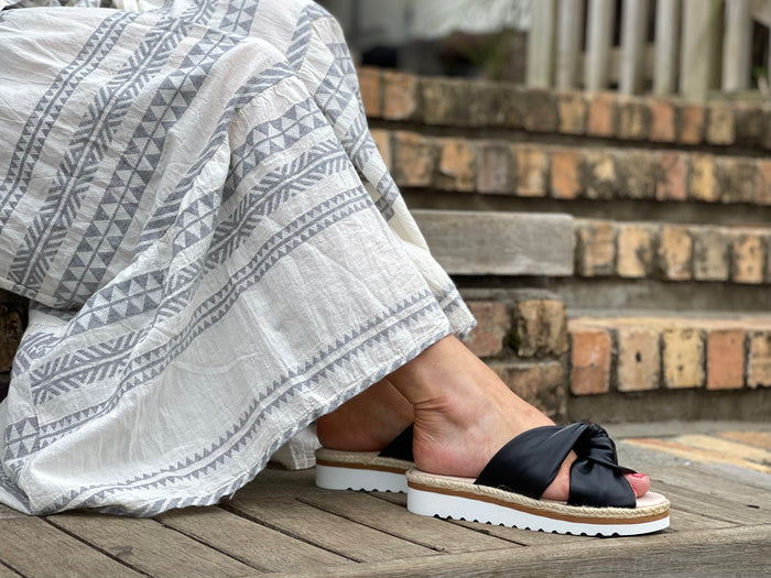 Aerobics are quality European women's sandals and slides. Soft leather with crossover knot detail in black. Espadrille detail around the sole unit.
