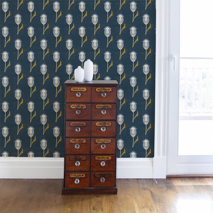 Abstract floral dark and light blue wallpaper on a wall with a brown cabinet in front with white vases on top