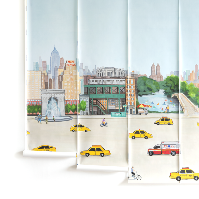 Bleecker fabric showing a detailed city scene with yellow taxis, cyclists, a park, and skyline against a pale blue sky