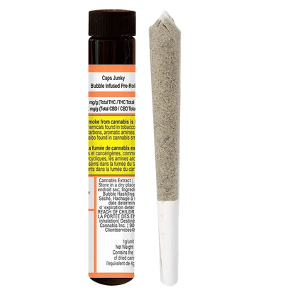 Vertical studio shot of a Caps Junky Bubble Infused PR 1 x 1g pre-roll standing beside its brown plastic tube, both shown on a white background.