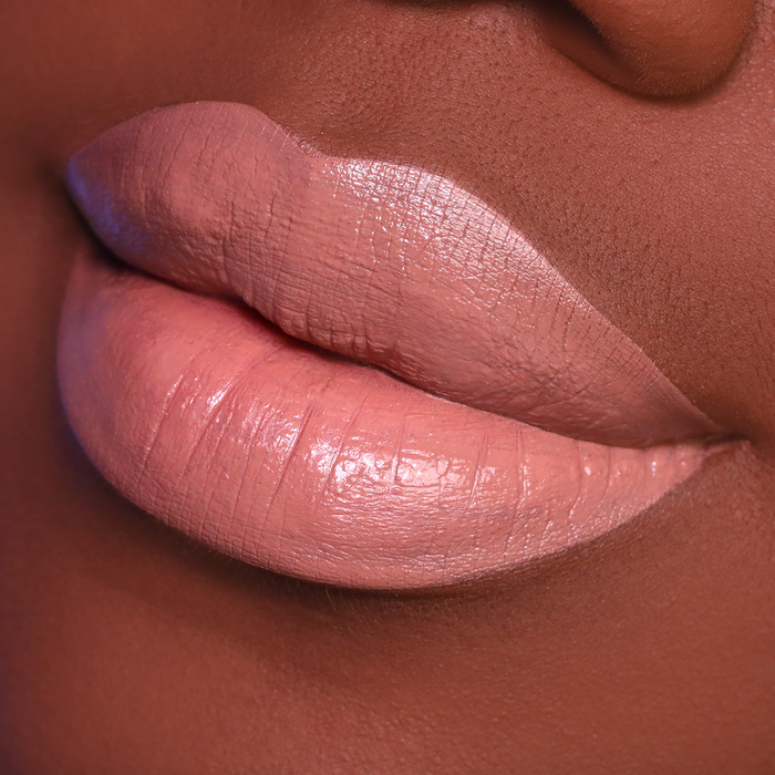 Caramel nude brown lipstick on lips, deep skin tone close-up
