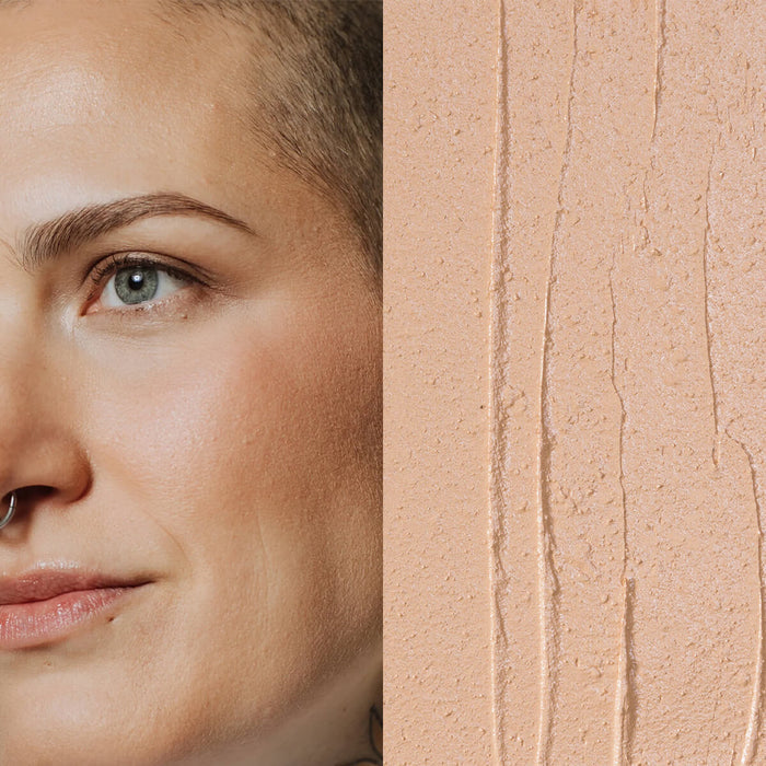 Model next to swatch of Elate Beauty Creme Concealer in the shade 'CN2', for light neutral skin tones. A two-in-one concealer and illuminator formulated with evening primrose oil, designed to heal and conceal blemishes.