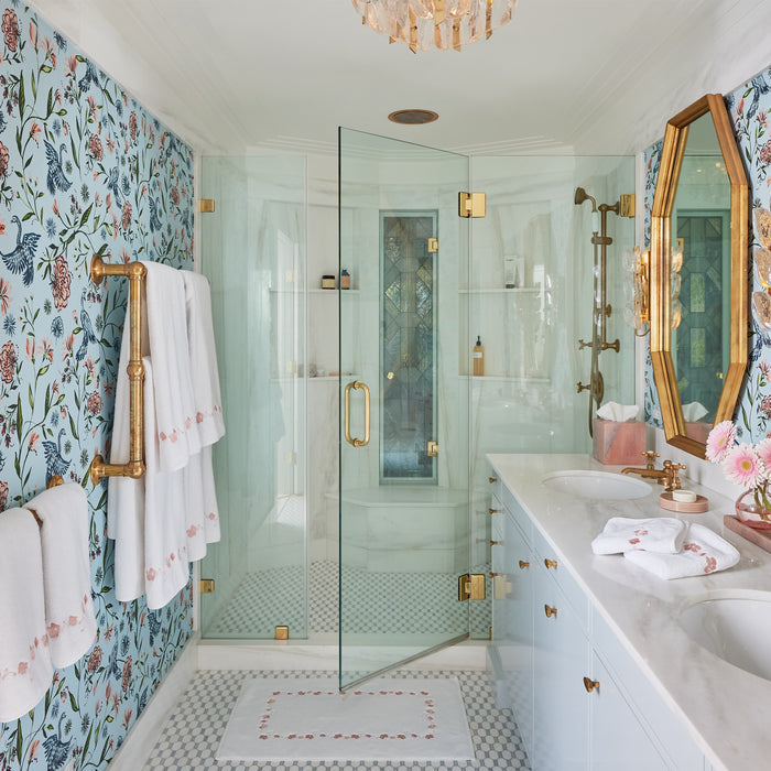 Bright bathroom with floral wallpaper, glass shower, brass fixtures, and Rossa Bath Accessories, made-to-order in the USA