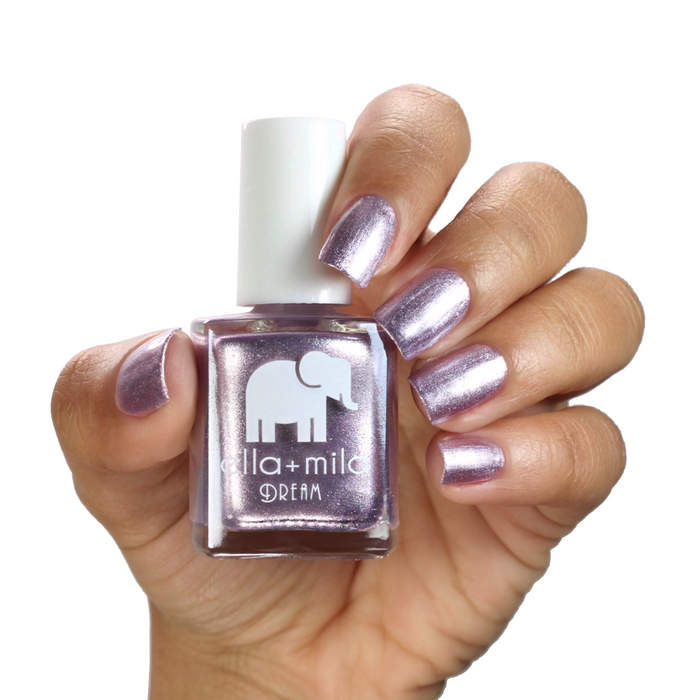 Dolled Up metallic lilac nail polish on a medium skin tone, hand holding the bottle
