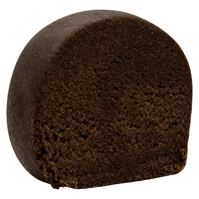 Close-up three-quarter view of a dense, dark brown half-log of East Coast Aged Hash showing its crumbly interior texture.