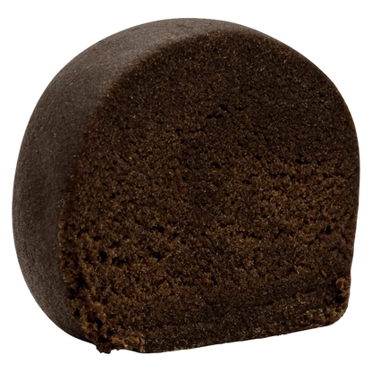 Close-up three-quarter view of a dense, dark brown half-log of East Coast Aged Hash showing its crumbly interior texture.