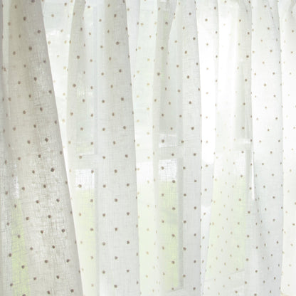 close up of white sheer curtain with neutral embroidered polka dots