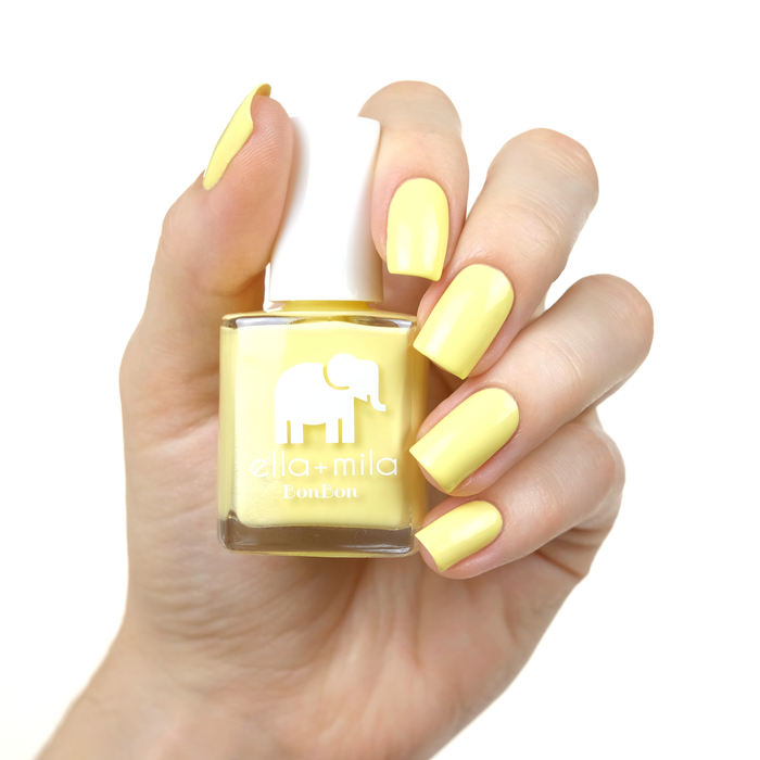 Hooray of Sunshine sunshine yellow nail polish manicure on a light skin tone with the bottle