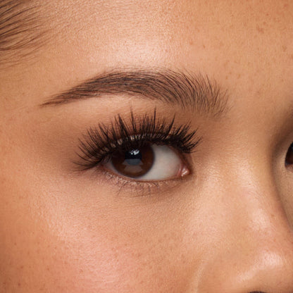 Close-up of a woman's forehead and eyebrow showing natural skin texture and pores