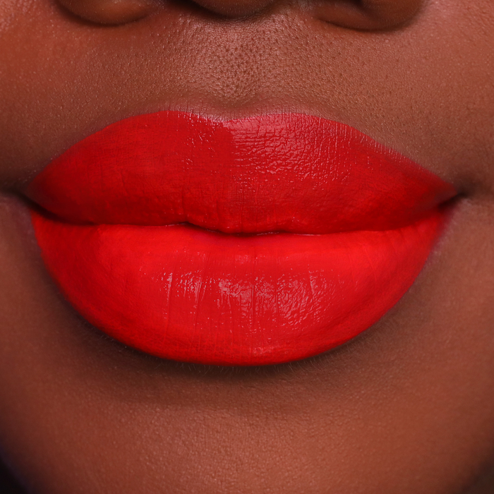 Island Girl orange red lipstick on lips, medium-deep skin tone