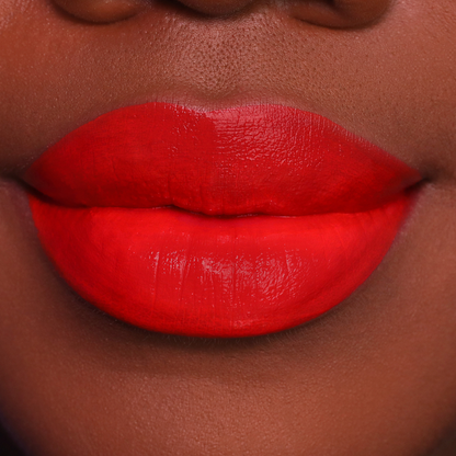 Island Girl orange red lipstick on lips, medium-deep skin tone