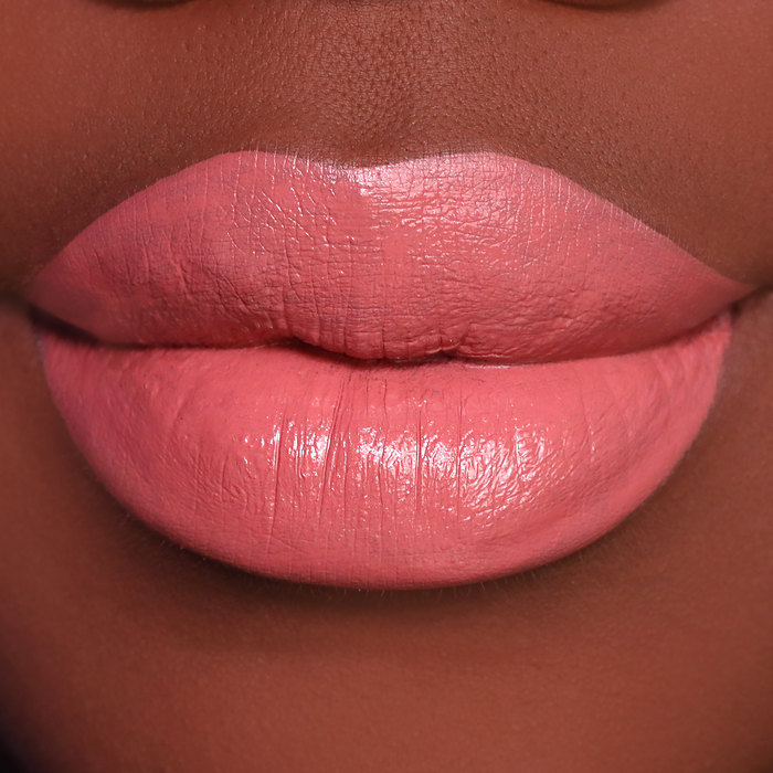 Just Enough peachy coral lipstick on lips, medium-deep skin tone