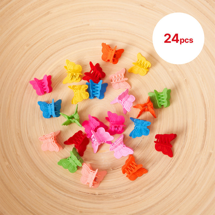 24pcs kids butterfly hair clips in various bright colors arranged on wooden surface