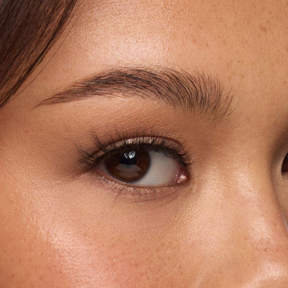 Kitty Cat false lashes features a natural flair for a subtle cat-eye effect, with wispy fibers, natural volume, and a short length shown on an eye.