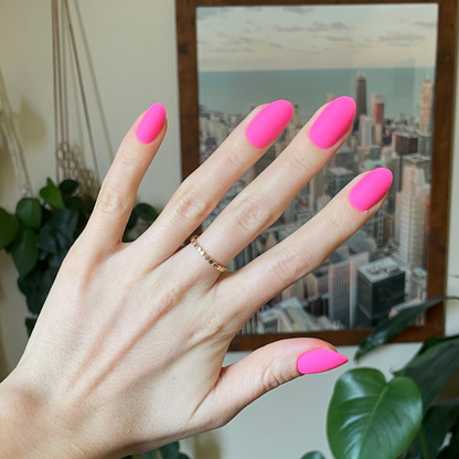 Matte Neon Flamingo - Press-On | Medium | Oval showing hand with medium oval neon pink matte press-on manicure indoors