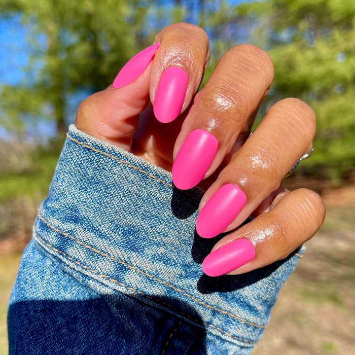 Matte Neon Flamingo - Press-On | Medium | Oval showing hand with medium oval hot pink neon matte press-on manicure outdoors