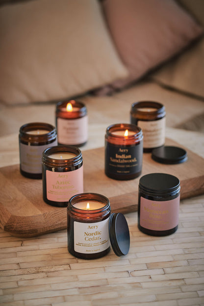 Collection of Fernweh jar candles by Aery displayed on wooden tray and cream table
