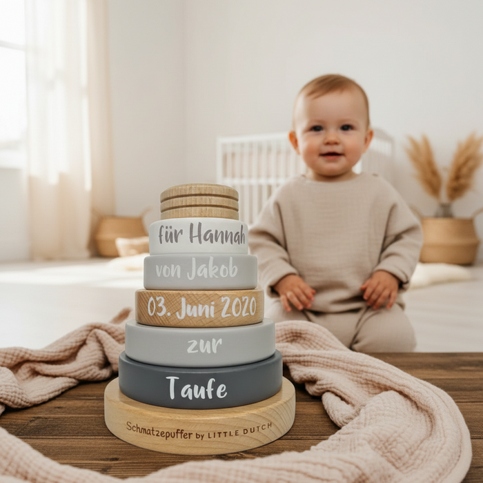 Baby im Kinderzimmer neben personalisiertem Stapelturm zur Taufe aus Holz