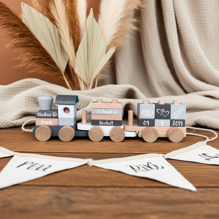 Personalisiertes Hochzeitsgeschenk als Holzzug mit Namen und Datum, dekoriert für das Brautpaar