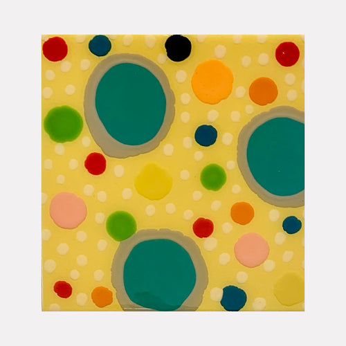 The artwork 'Piece of Cake 936' by Lori Kirkbride features playful circular patterns on a soft yellow background. Large turquoise circles anchor the composition, while smaller dots in red, orange, green, and pink create a dynamic, confetti-like scatter. The acrylic and resin artwork evokes a modern, whimsical aesthetic with its polka dot design.