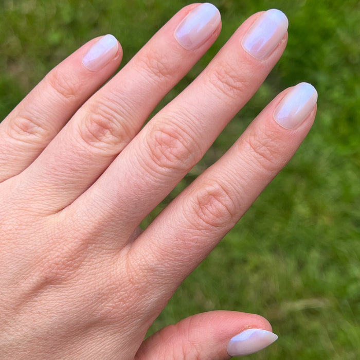 Pink Goldfish | Round | Extra Short iridescent pink press on nails in extra short round shape on hand outdoors