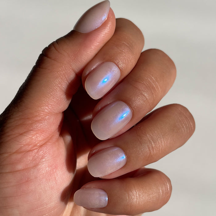 Pink Goldfish | Round | Extra Short iridescent pink press on nails in extra short round shape on hand with natural light