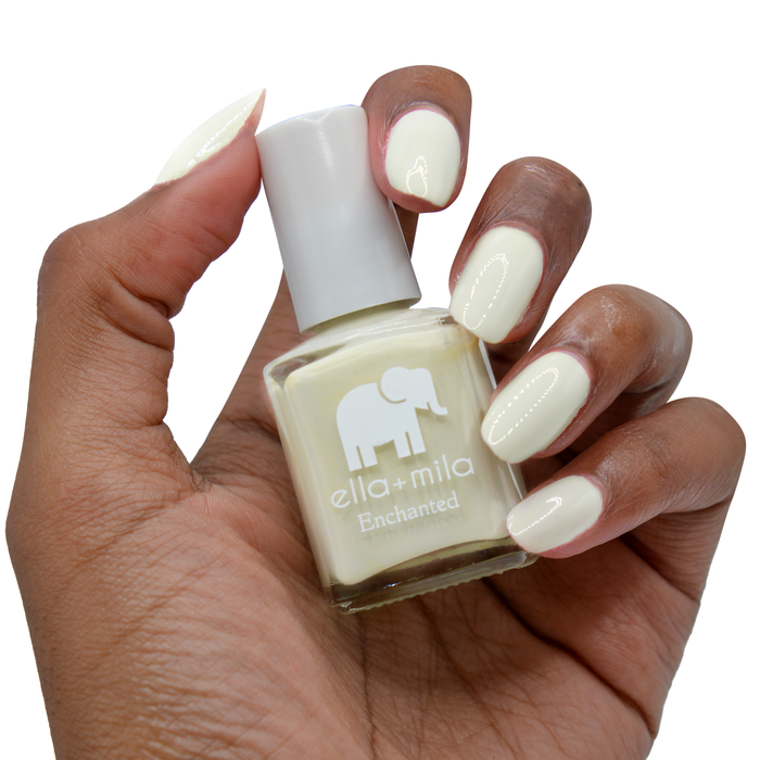 Sacred Sage sage green nail polish on a deep skin tone, hand holding the bottle