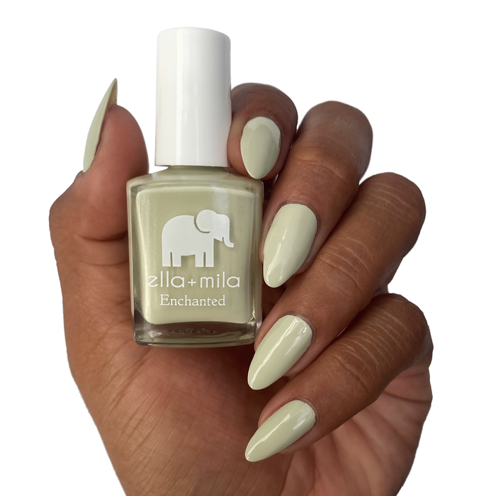 Sacred Sage dusty green nail polish on a deep skin tone, holding the bottle