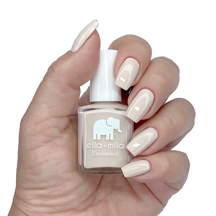 Secret Garden creamy nude nail polish manicure on a light skin tone with the bottle