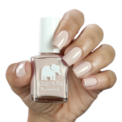 Secret Garden creamy nude nail polish on a medium skin tone, hand holding the bottle