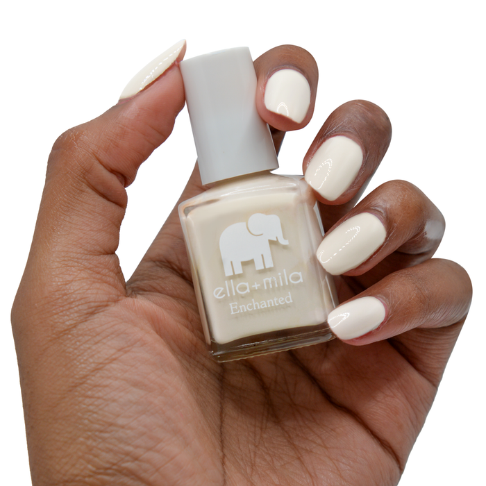 Secret Garden creamy nude nail polish on a deep skin tone, hand holding the bottle