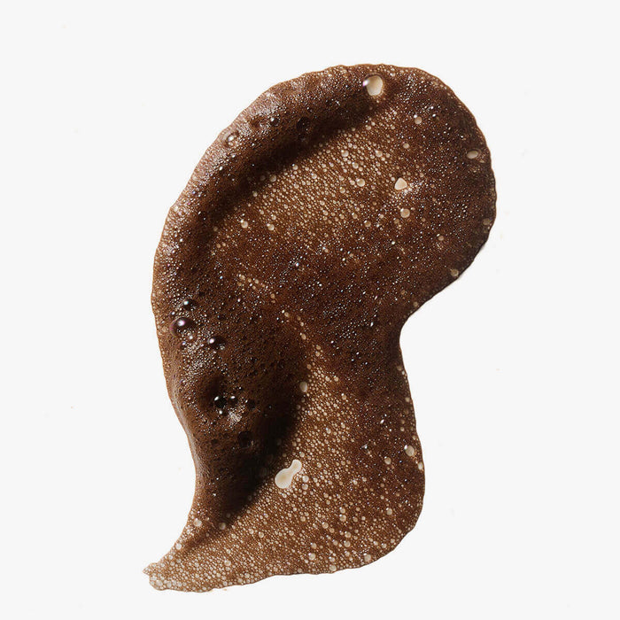 Brown sludge-like substance on a white background.
