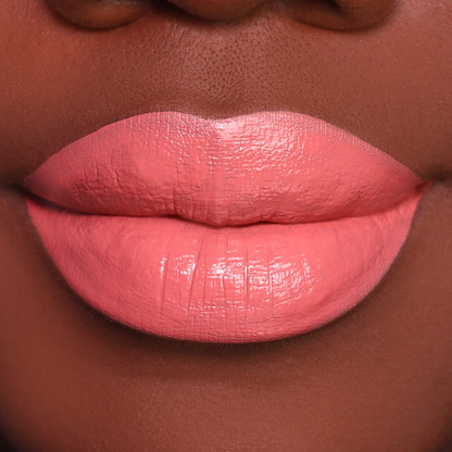 Set Plans peach coral lipstick on lips, medium-deep skin tone