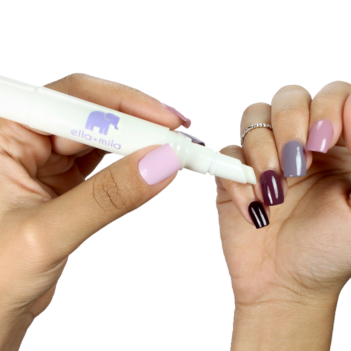 Applying Soften Me Up lavender cuticle oil pen to a lilac and plum manicure