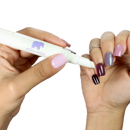 Applying Soften Me Up lavender cuticle oil pen to a lilac and plum manicure