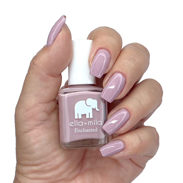 Spellbound pink lilac nail polish on a medium skin tone, hand holding the bottle