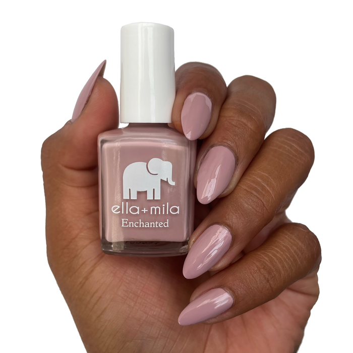 Spellbound pink lilac nail polish on a deep skin tone, hand holding the bottle