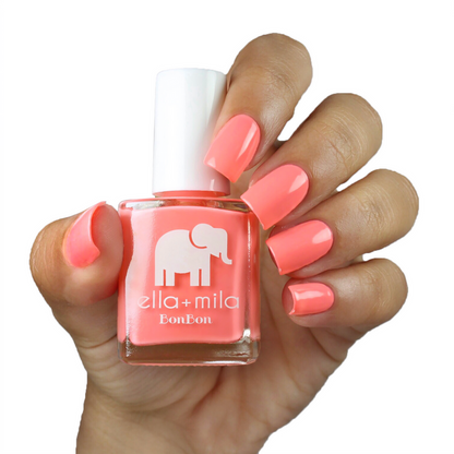 Sugar Rush peachy pink nail polish on a medium skin tone, hand holding the bottle