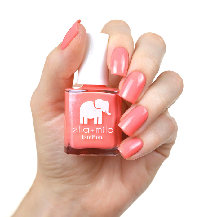 Sugar Rush bright peachy pink nail polish manicure on a light skin tone with the bottle