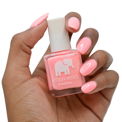 Sugar Rush peachy pink nail polish on a deep skin tone, hand holding the bottle