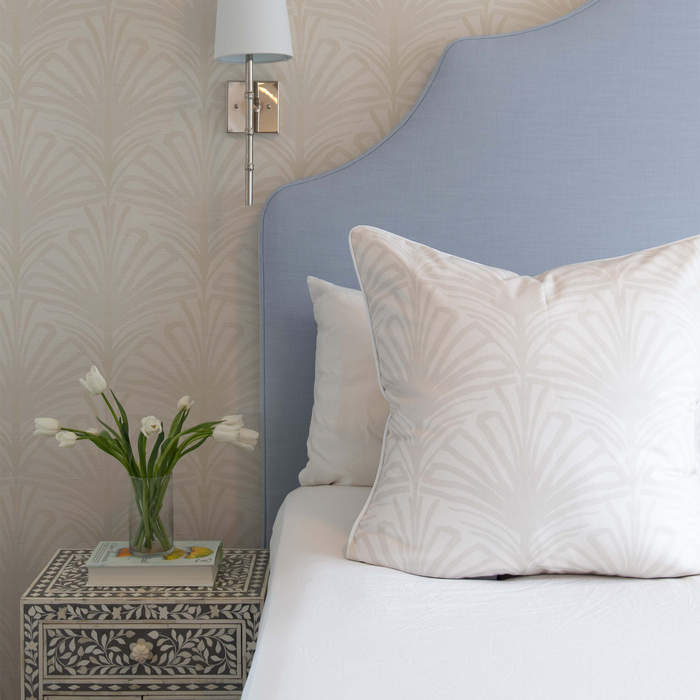 Suzy Sand fabric pillow with subtle palm leaf pattern on bed with floral wallpaper, made-to-order, short lead times, USA made