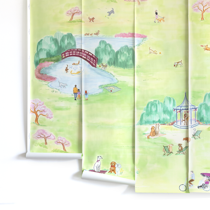 Tate mural with a light pastel park scene featuring people, dogs, trees, a pond, and a red arched bridge