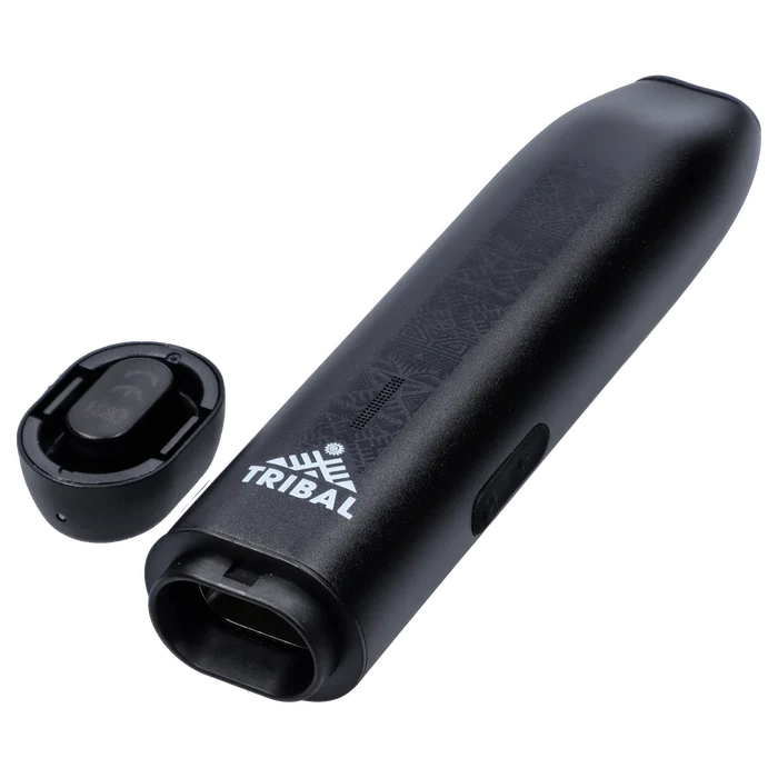 Angled close-up of the black Tribal Aerolith Dry Herb Vaporizer showing its embossed pattern, white TRIBAL logo, mouthpiece opening, and detached magnetic cap.