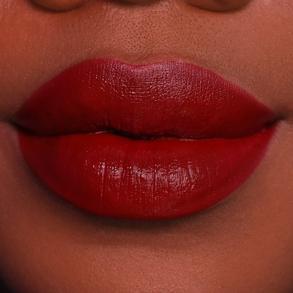 Vampy deep red lipstick on lips, medium-deep skin tone