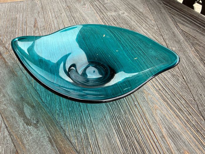 Teal glass bowl on a wooden surface